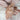 Child's hands wearing a bracelet and ring with floral designs on a soft fabric background