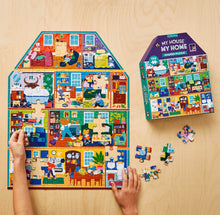 Load image into Gallery viewer, hands shown placing a piece on house shaped puzzle with box for puzzle in view