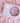 A bead kit by lauren hinkley featuring various colorful beads and finished bracelet projects displayed on a pink background.